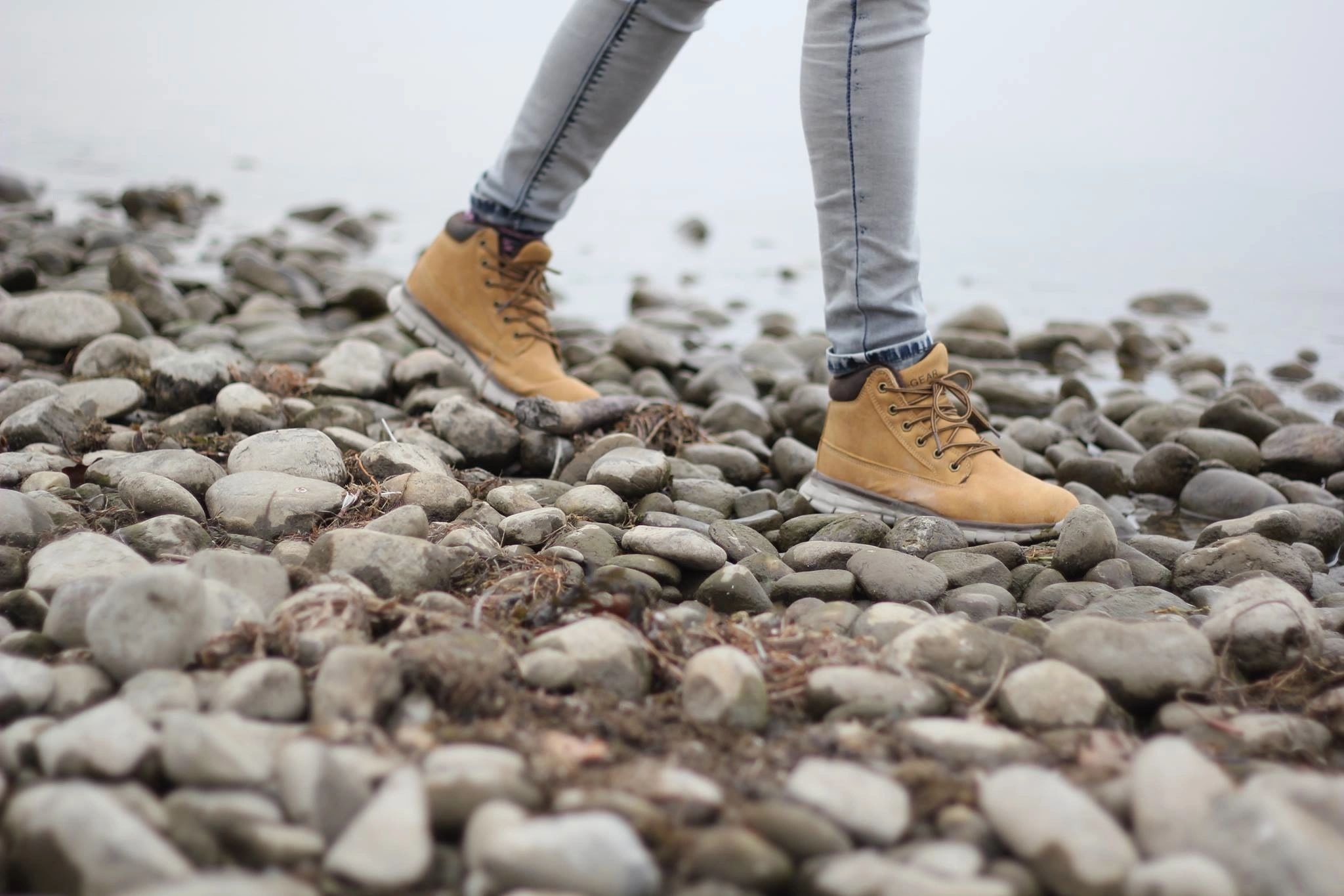 Person walking on a rocky waterfront, walking towards a new life after getting alcohol use disorder treatment